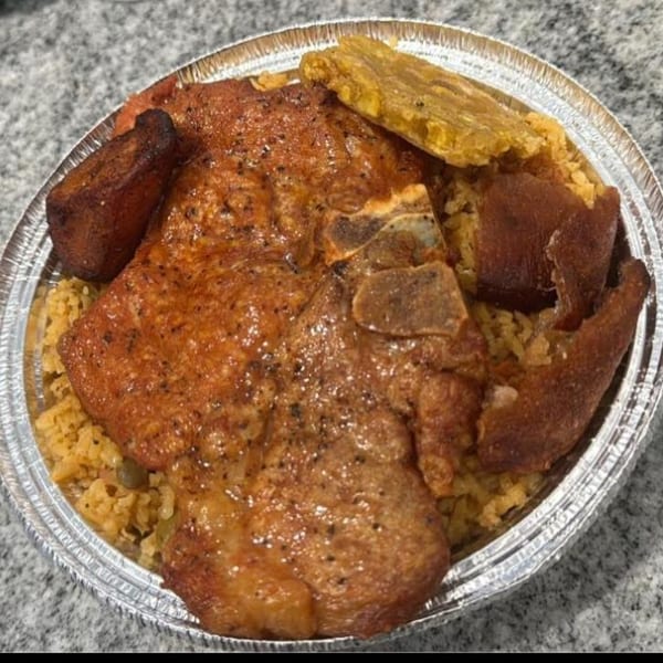 El Gordo Coqui's Spanish dish with pork chops, yellow rice, fried plantains, and pork skin.
